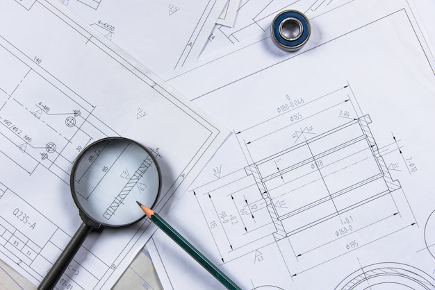 Drafted pipe layout drawing on a table with a scale rule